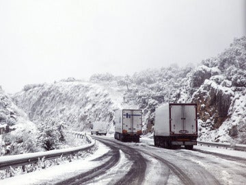 Varios camiones en una carretera nevada