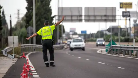 Un agente de la Guardia Civil de Tráfico da el alto a un conductor en un control Un agente de la Guardia Civil de Tráfico da el alto a un conductor en un control