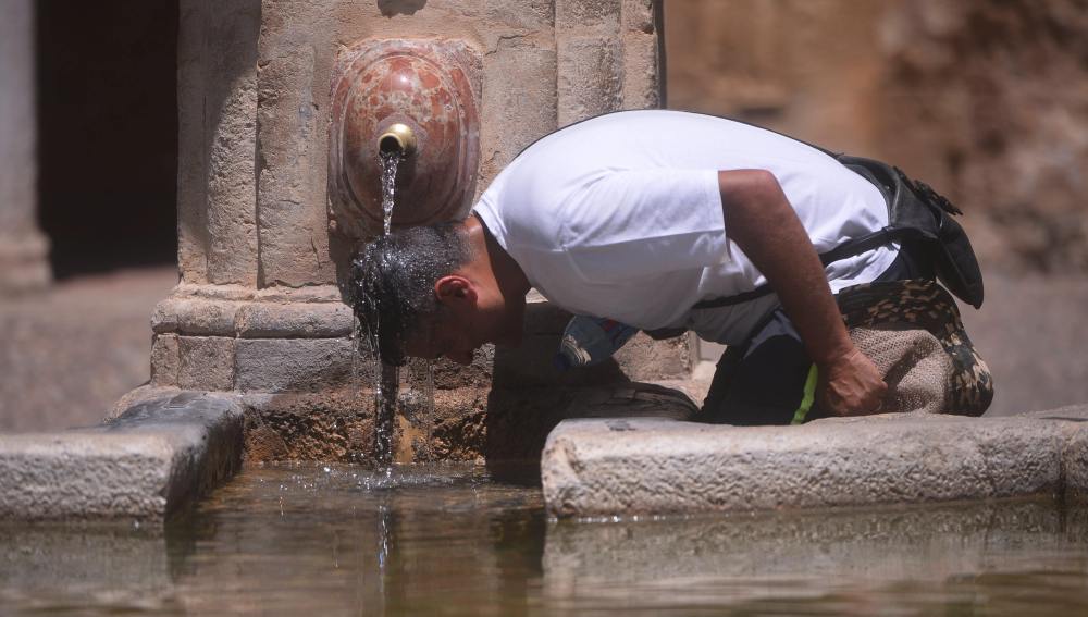 Un hombre combate el calor en una fuente