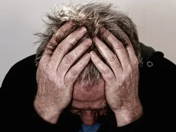 Imagen de archivo de un hombre sufriendo dolor de cabeza Imagen de archivo de un hombre sufriendo dolor de cabeza