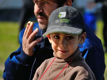 Un niño junto a un adulto fumando Un niño junto a un adulto fumando