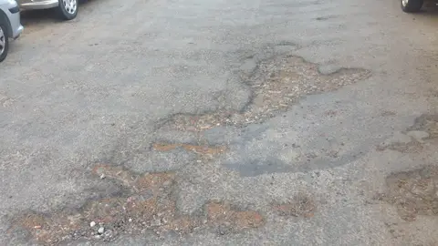 Calle en muy mal estado en Santiago de la Ribera, Murcia La Calle carril de las palmeras en santiago de la Ribera con mucho tráfico en verano está llena dé socavones