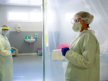 Personal sanitario con EPI en una UCI Personal sanitario con EPI en una UCI