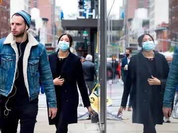 Personas con y sin mascarilla caminan por una calle de Nueva York Personas con y sin mascarilla caminan por una calle de Nueva York