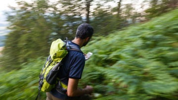 Excursionista perdido en la montaña con móvil Excursionista perdido en la montaña con móvil