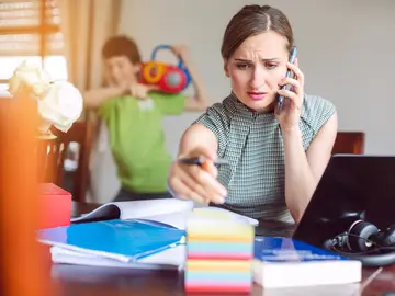 Mujer teletrabajando con sus hijos en casa Mujer teletrabajando con sus hijos en casa