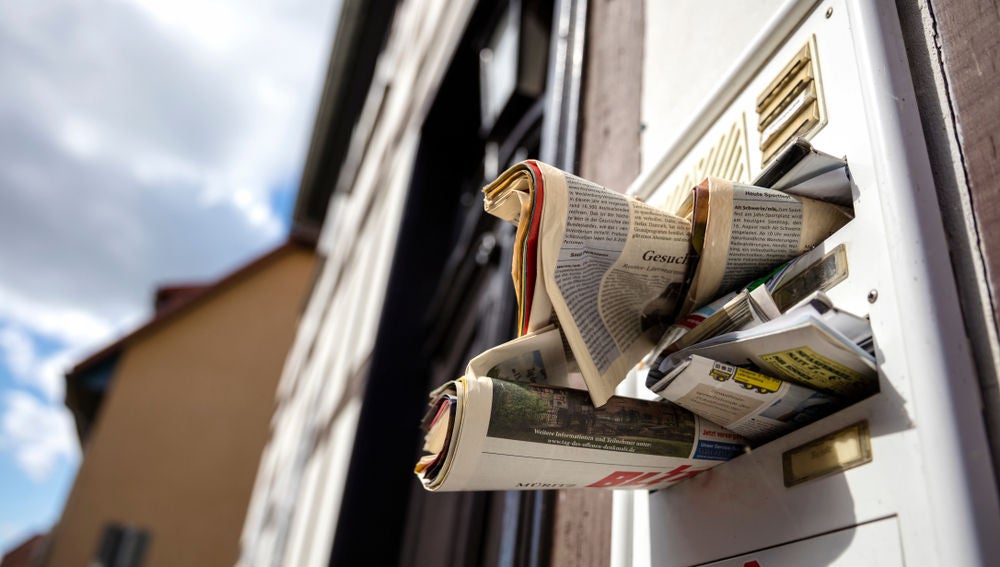 Periódicos acumulados en una puerta sugieren que alguien lleva tiempo sin pasar por casa.