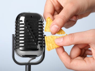 Unas manos rompen un snack cerca de un micrófono