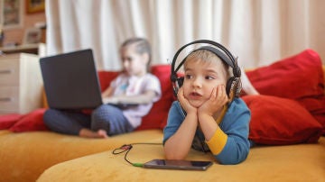 Dos niños usando dispositivos tecnológicos Dos niños usando dispositivos tecnológicos