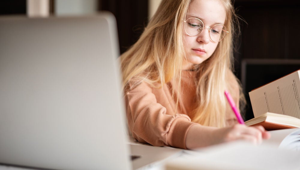 Adolescente estudia con su portátil.