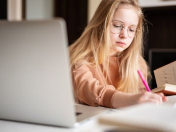 Adolescente estudia con su portátil.