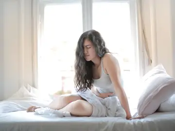 Mujer con dolor en los ovarios Mujer con dolor en los ovarios