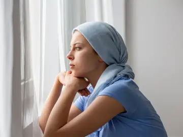 mujer con cáncer mirando por la ventana mujer con cáncer mirando por la ventana