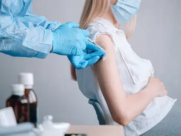 Mujer embarazada a la que le están administrando una vacuna Mujer embarazada a la que le están administrando una vacuna
