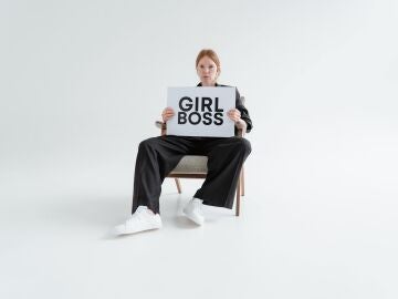 Mujer joven sostiene cartel que pone “girl boss” 