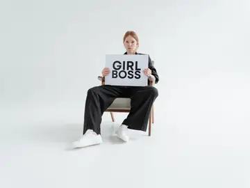 Mujer joven sostiene cartel que pone “girl boss” Mujer joven sostiene cartel que pone “girl boss”
