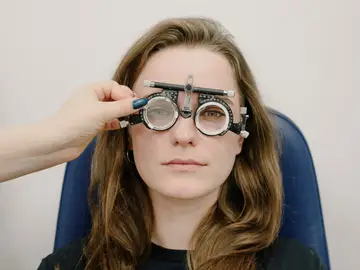 Chica revisándose la vista en el oftalmólogo Chica revisándose la vista en el oftalmólogo