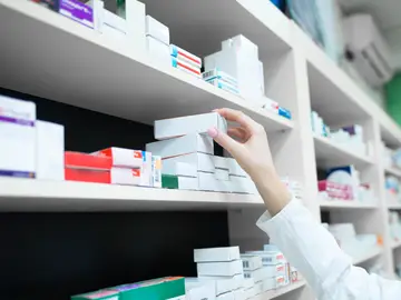 Farmacéutica cogiendo un medicamento Farmacéutica cogiendo un medicamento