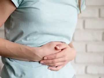Una mujer con dolor de estómago o hinchazón. Una mujer con dolor de estómago o hinchazón.