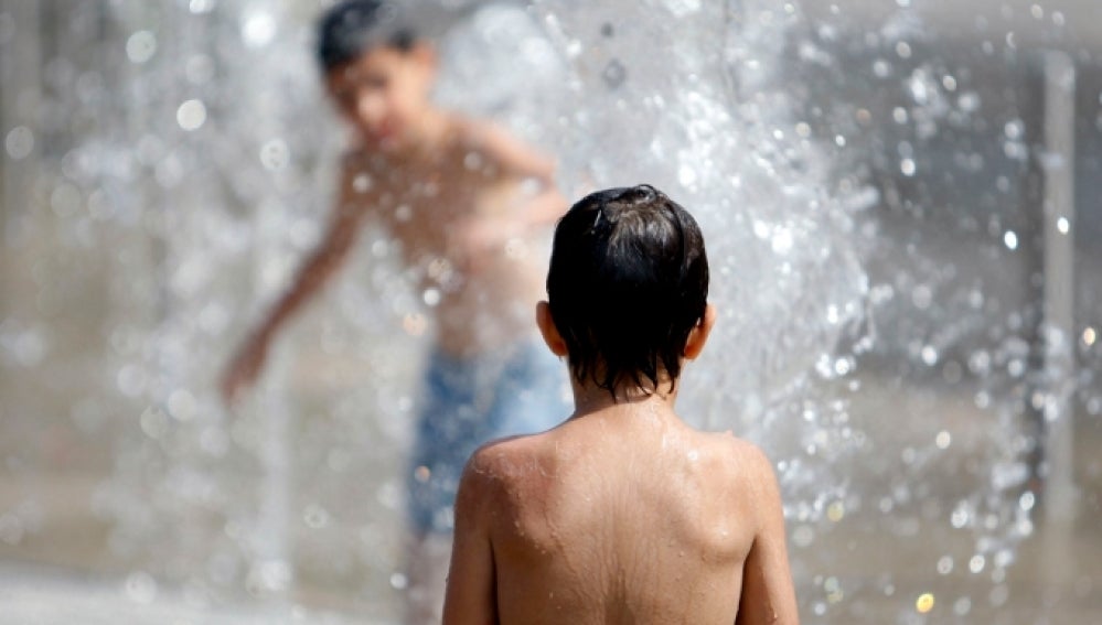 Niños se bañan para soportar el calor
