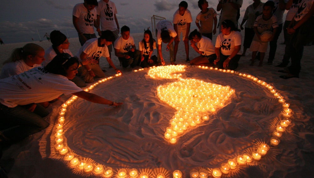 Dibujan Sudamérica con velas en la playa de Cancún