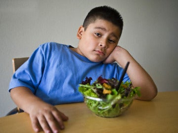 Niño obeso con una ensalada