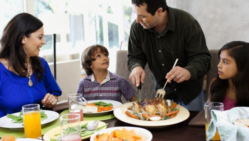 Unos padres sirven comida a sus hijos
