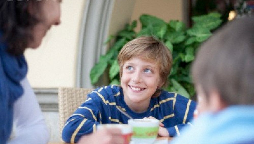 Niño comiendo en familia.