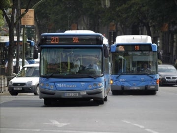 Dos autobuses de la EMT circulan por el madrileño Paseo de la Castellana