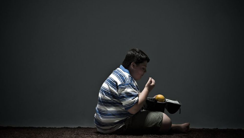 Niño con problemas de obesidad comiendo