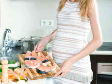 Embarazada  cocinando pescado