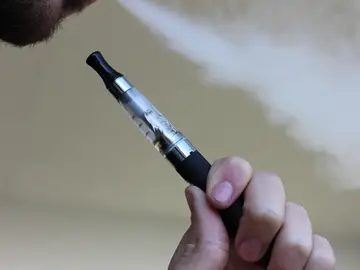 Imagen de archivo de una persona con un cigarrillo electrónico. Imagen de archivo de una persona con un cigarrillo electrónico.