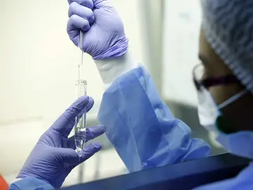 Una mujer examinando pruebas en un laboratorio Una mujer examinando pruebas en un laboratorio