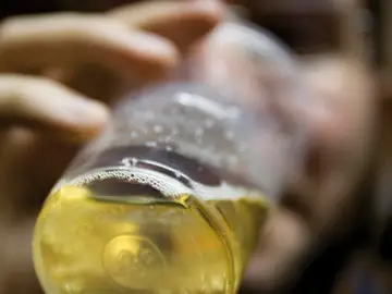 Un joven bebe una bebida alcohólica Un joven bebe una bebida alcohólica