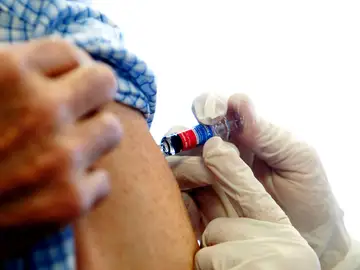 Una enfermera administra la vacuna de la gripe Una enfermera administra la vacuna de la gripe