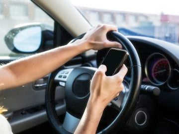 Imagen de un conductor utilizando el móvil al volante.