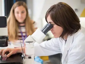 Una científica usando un microscopio. Una científica usando un microscopio.