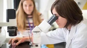 Una científica usando un microscopio. Una científica usando un microscopio.