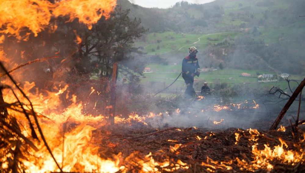 Un efectivo del Cuerpo de Bomberos de Cantabria durante las labores de extinción de un incendio forestal
