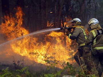 Los bomberos apagan un fuego en Rianxo, Galicia.