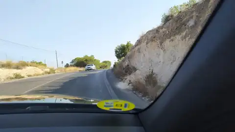 Enlace Calle Alcazar de Segovia con C/ Ibiza , Orihuela Costa Se trata de tres denuncias encadenadas de las calles Cabo Creus, Alcazar de Segovia y de un tramo de 900m entre esta última y la rotonda con la calle Ibiza, en el término municipal de Orihuela Costa. En los tres tramos se dan las mismas circunstancias, muy mal estado de la calzada, con agujeros, alcantarillas hundidas y sobreelevadas, señalización vertical en mal estado (oxidadas y no visibles), sin iluminación, barreras quitamiedos rotas por accidentes previos y no reparadas, invasión permanente de vegetación en la calzada, desprendimientos contínuos de los terraplenes adyacentes a la vía, y lo peor de todo como se puede apreciar en las fotos en los costados de la vía no existe espacio para transitar a pie, y se da la circunstancia que los tres tramos son utilizados por numerosas peatones, algunos con coches de bebé, minusvalidos con vehiculos eléctricos de pequeñas dimensiones durante todo el día y las primeras horas de la noche para acceder a las zonas de playa y ocio existentes ras cruzar por encima de la AP-7. El riesgo de accidente es extremo. Estas circunstancias han sido puestas por mí en conocimiento del Ayuntamiento de Orihuela hace más de un año, y la respuesta fue que tomaban nota de ello, y eso hasta el día de la fecha 23/07/19 en que el estado de estas vías no sólo no ha mejorado sino que con el paso de este tiempo ha empeorado.