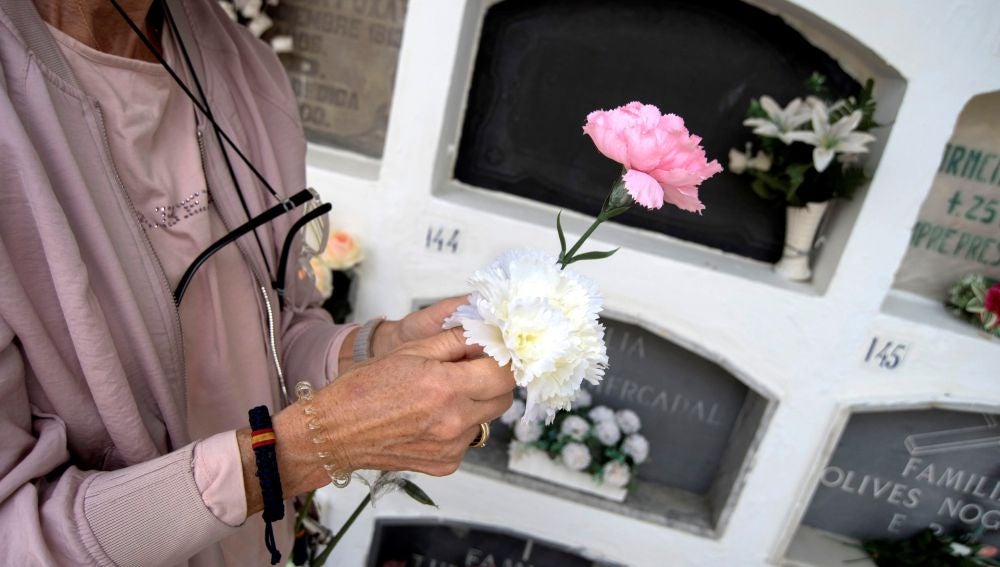 Mujer dejando flores en un cementerio