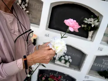 Mujer dejando flores en un cementerio Mujer dejando flores en un cementerio
