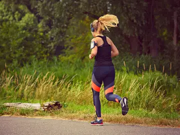 Mujer practicando running mientras escucha música Mujer practicando running mientras escucha música