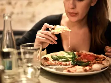 Mujer comiendo pizza Mujer comiendo pizza