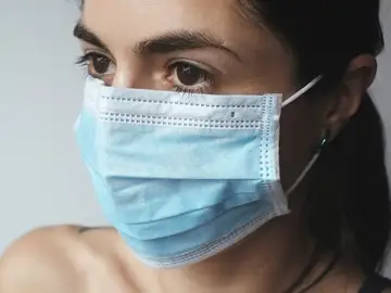 Una mujer con una mascarilla quirúrgica Una mujer con una mascarilla quirúrgica