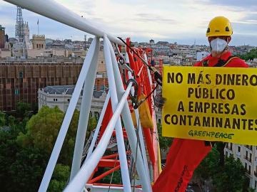 Vista de la pancarta desplegada por Greenpeace en la Plaza de Neptuno, en Madrid, para exigir que no se destine más dinero público a empresas contaminantes