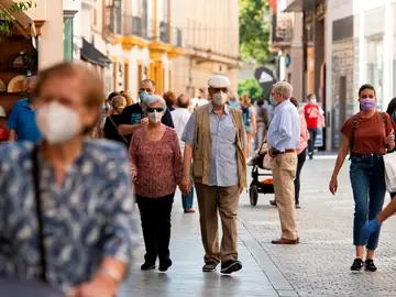 Gente caminando por la calle con mascarilla Gente caminando por la calle con mascarilla