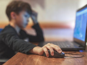 Un niño consulta su ordenador portátil