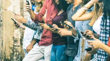 Varios jóvenes miran sus móviles Varios jóvenes miran sus móviles